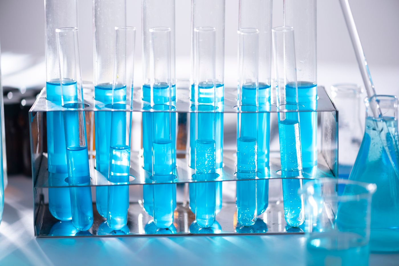 Laboratory test tubes and glassware containing blue liquid
